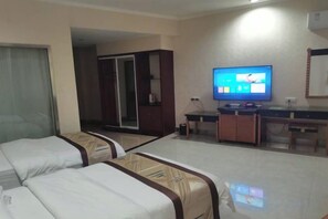 A hotel room with two beds, a television, a desk, and a wardrobe. - Changshou Business Hotel (Luntai)
