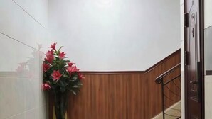 A hallway with a potted plant, wooden paneling, and a staircase. - Shuangqiao District Haoshen Hotel (Chongqing)