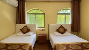 A hotel room with two single beds, a nightstand, an air conditioning unit, and a window with curtains. - Shuangqiao District Haoshen Hotel (Chongqing)