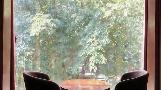 A room with a large window, two chairs, and a round table. - Shuangqiao District Haoshen Hotel (Chongqing)