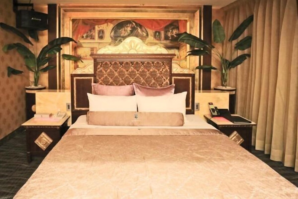A bed with a headboard, two bedside tables, and a nightstand.