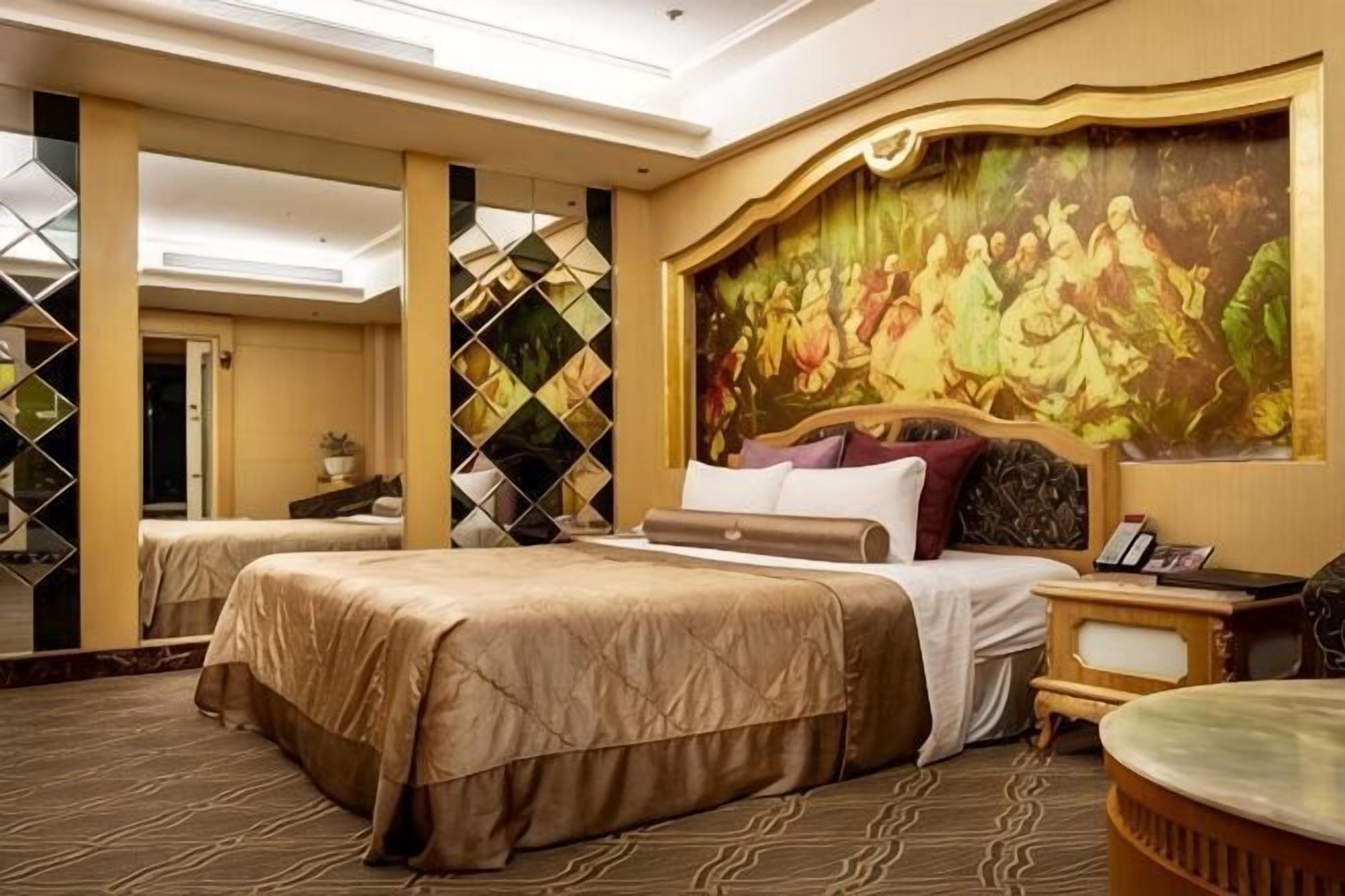 A hotel room with two beds, a large mural, and a decorative wall.