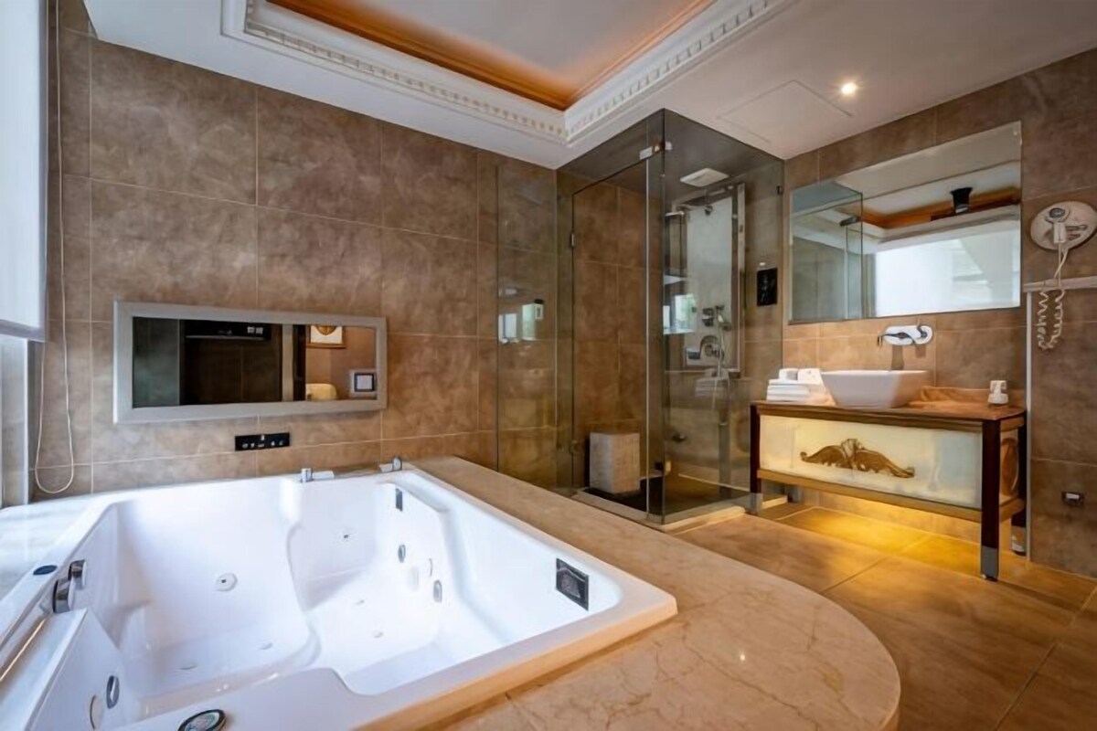 A modern bathroom with a large bathtub, a glass shower enclosure, and a vanity with a sink.
