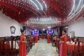 A banquet hall with tables and chairs arranged for a formal event. - Youyicun Hotel (Pingdu)