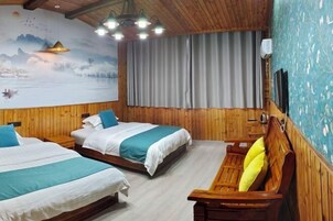 A room with two beds, a wooden bench, a mural, and a curtain.