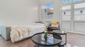 A modern bedroom with a bed, a glass table, and a view of the outside. - Funchal City Nest I (Funchal)
