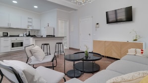 A modern living room with a sofa, chairs, a coffee table, and a TV mounted on the wall. - Funchal City Nest I (Funchal)