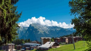 A mountain resort with buildings, a ski lift, and a clear view of the mountains. - Beautiful 3-bed apartment, ski-in with wifi (Morillon 1100)