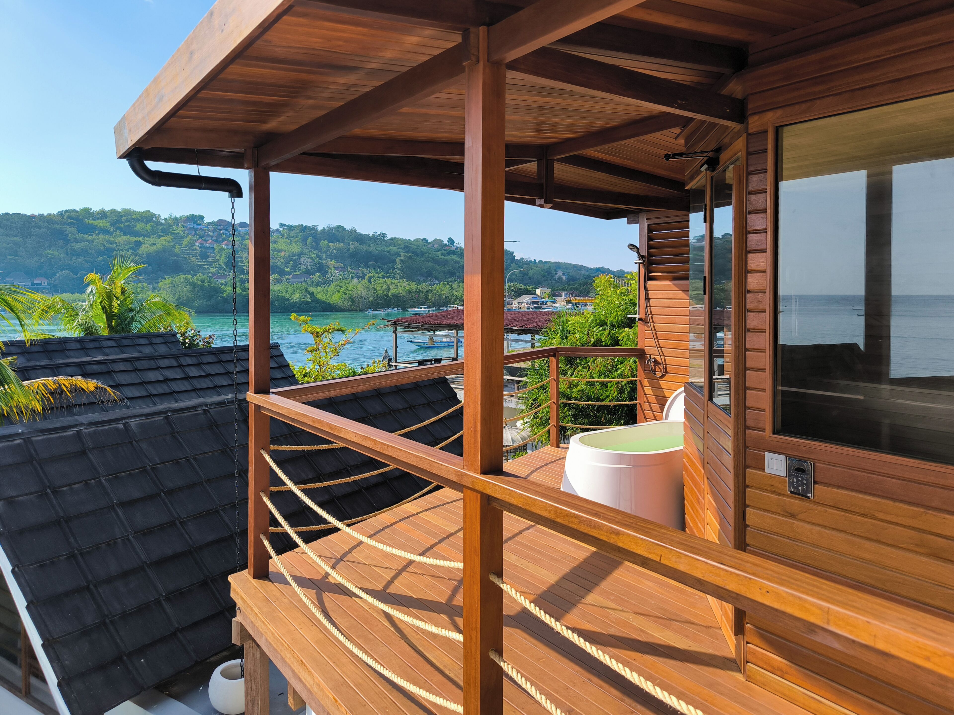 A wooden deck with a view of a lake and hills.