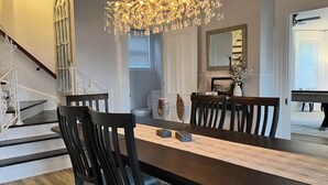 Un comedor con una mesa de madera grande, sillas oscuras y un candelabro.