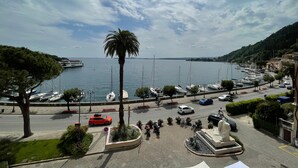 Una marina con barcos, una palmera y una estatua al frente.