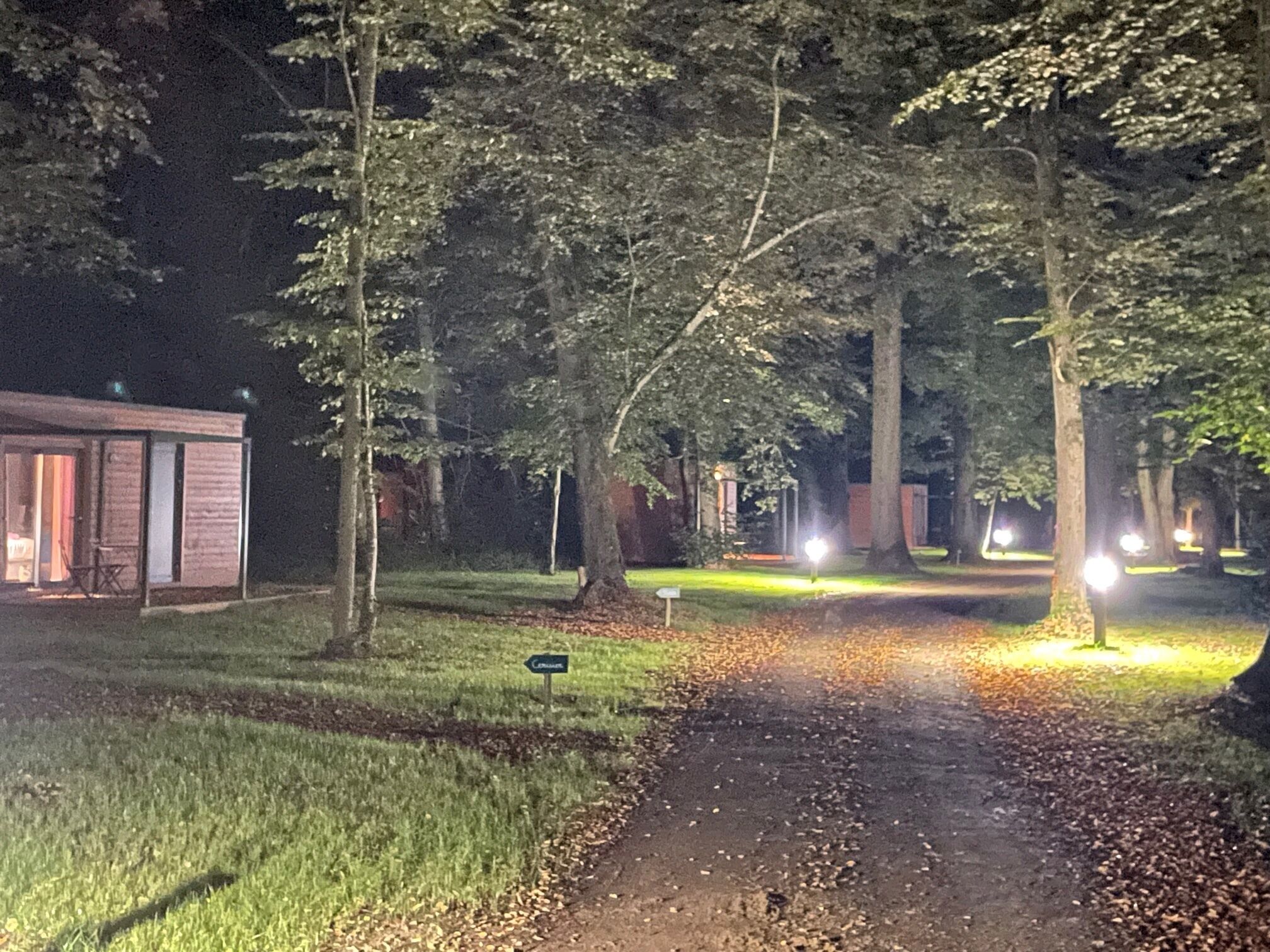 A pathway leading to a building with a sign indicating 'Cottages'.