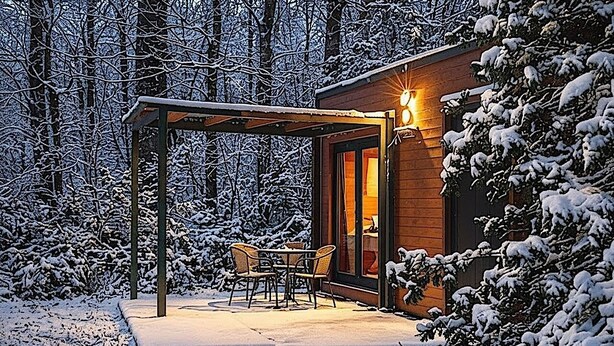 A cozy wooden cabin with a covered patio and a dining area. - Hôtel Les Lodges De Vaugrigneuse (Vaugrigneuse)