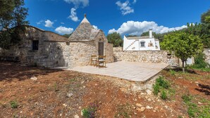 A stone building with a conical roof and a white building with a staircase. - 4010 Tenuta I Trulli Rochira by Barbarhouse (Ceglie Messapica)