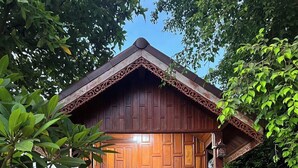 A wooden structure with a porch and steps leading to a door. - Natura Ravee Greenstay (Mae Taeng)