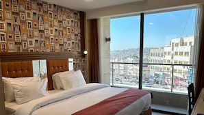 Habitación de hotel con una cama grande, vistas a la ciudad y un diseño moderno.