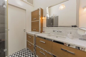A bathroom with a shower, a sink with a mirror, and a toilet. - Rebecca Suite Florence (Firenze)