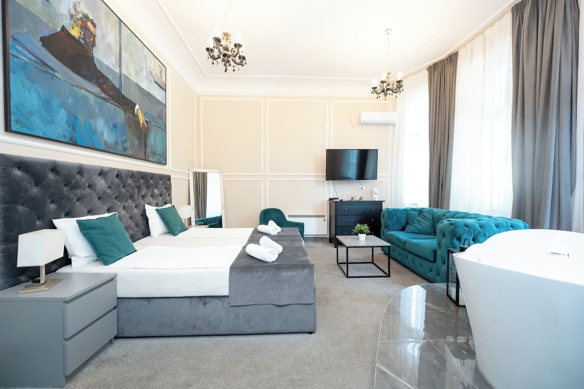 Ein modernes Hotelzimmer mit einem großen Bett, einer Couch, einem Fernseher und einem Bild an der Wand.