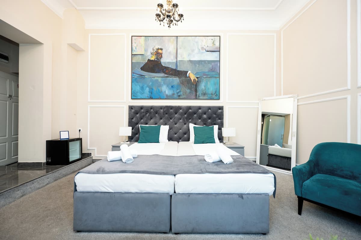 Ein modernes Schlafzimmer mit einem großen Bett, einem Fernseher und einem Bild an der Wand.