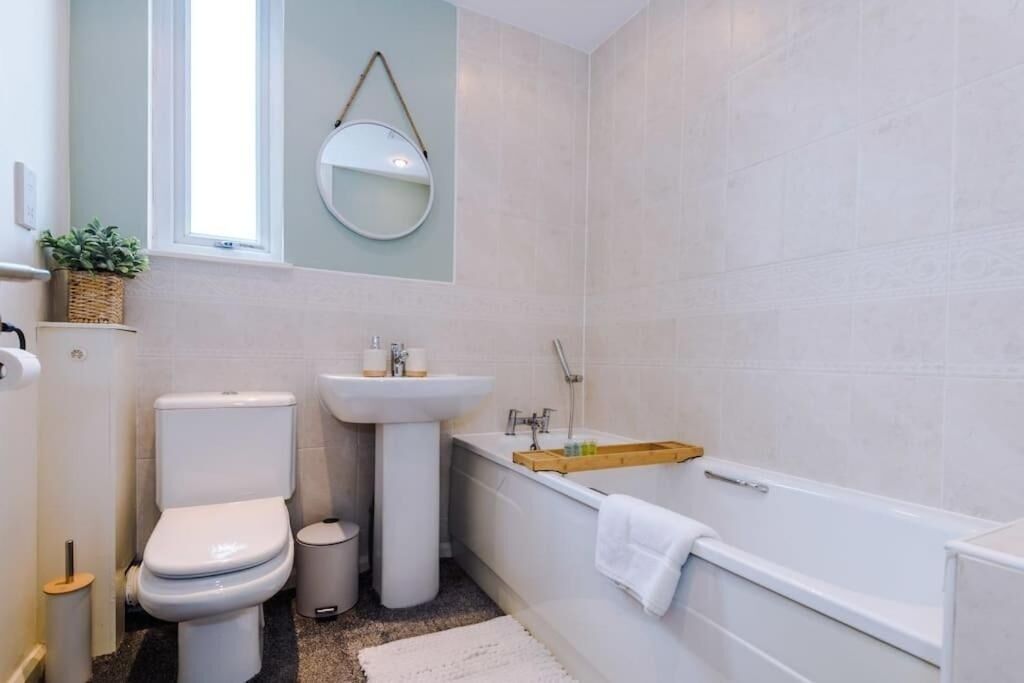 A bathroom with a toilet, sink, and bathtub.
