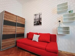 Relax in this stylish living room with a sofa, wardrobe, and framed artwork.