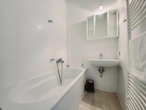 A modern bathroom with a bathtub, a sink, and a mirror. - Wipplinger Home Apartment Vienna (Vienna)