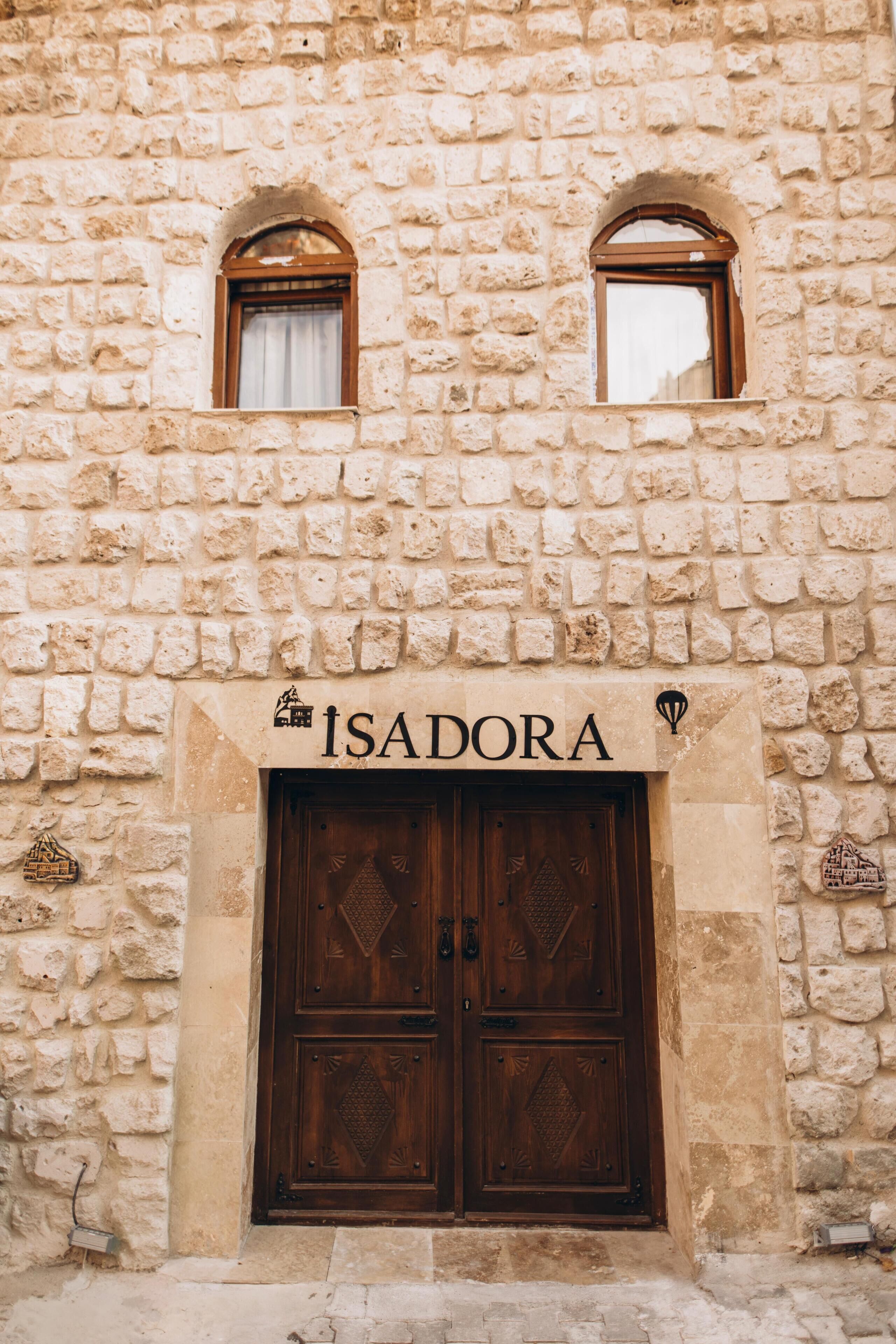 Ein Steinhaus mit einem Schild, auf dem „ISADORA“ steht, über einer hölzernen Doppeltür.