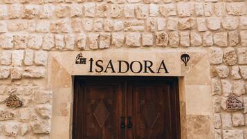 Ein Steinhaus mit einem Schild, auf dem „ISADORA“ steht, über einer hölzernen Doppeltür.