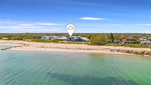 Una propiedad costera con vistas a la playa, con casas modernas y una piscina.