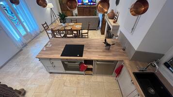 Une cuisine moderne dotée d’un plan de travail en bois, d’un four encastré et d’un évier en acier inoxydable.