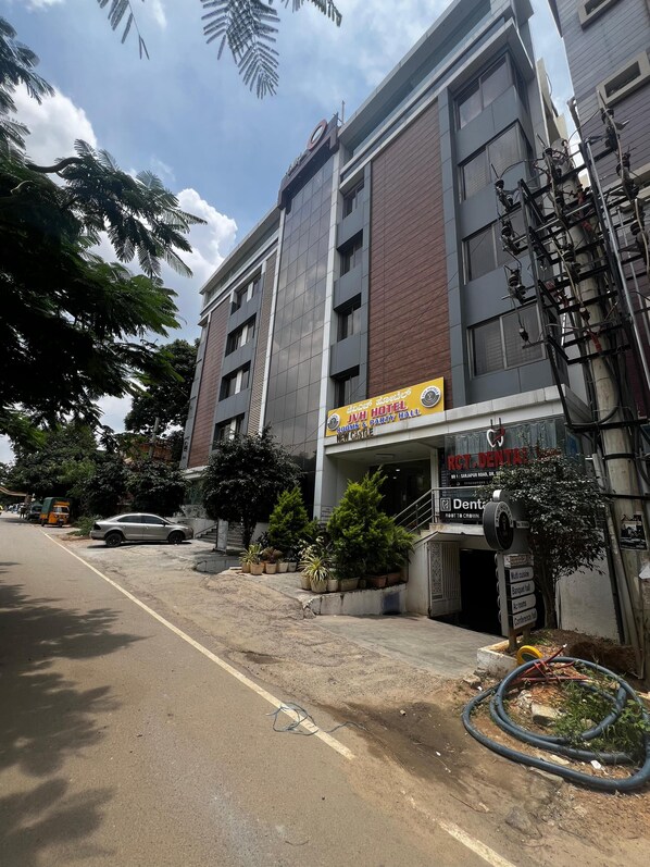 A hotel with a sign for rooms and party hall, a staircase leading to the entrance, and a sign for a dental clinic.
