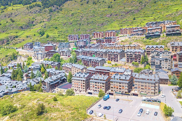 A cluster of multi-story buildings with a parking lot in the foreground.