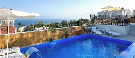 Seasonal outdoor pool, open 8:00 AM to 8:00 PM, pool umbrellas