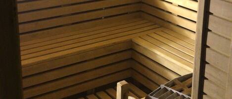 A sauna with wooden benches and a slatted floor.