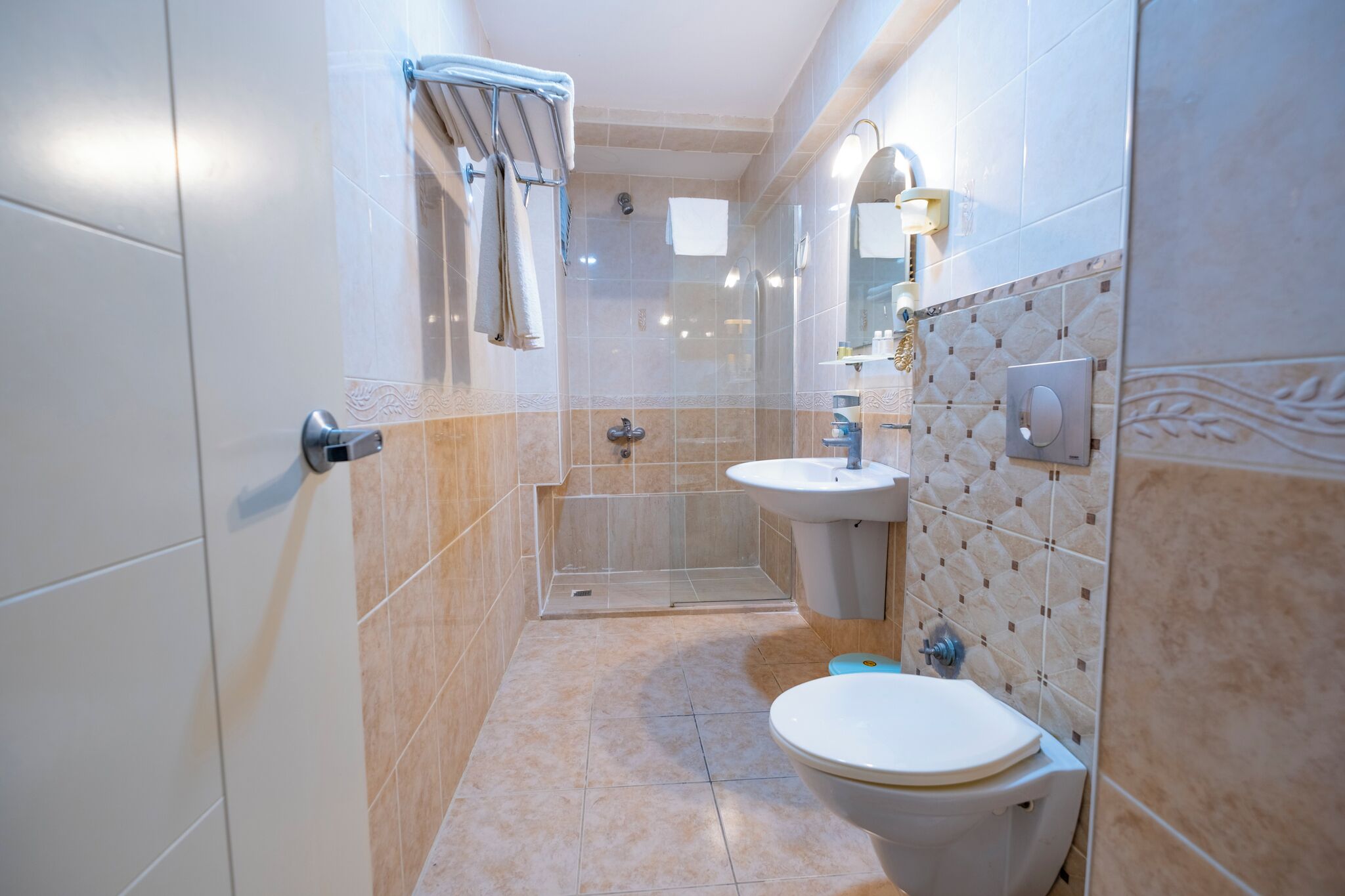 A modern bathroom with a shower, toilet, and sink.