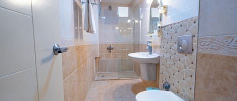 A modern bathroom with a shower, toilet, and sink.