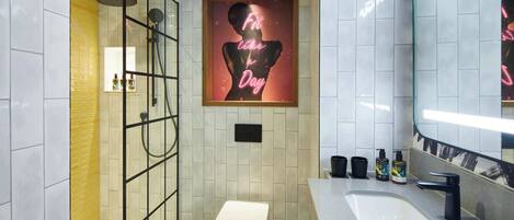 Ein modernes Badezimmer mit einer gläsernen Duschkabine, einer weißen Toilette, einem großen Spiegel und einem leuchtenden Neonzeichen an der Wand.