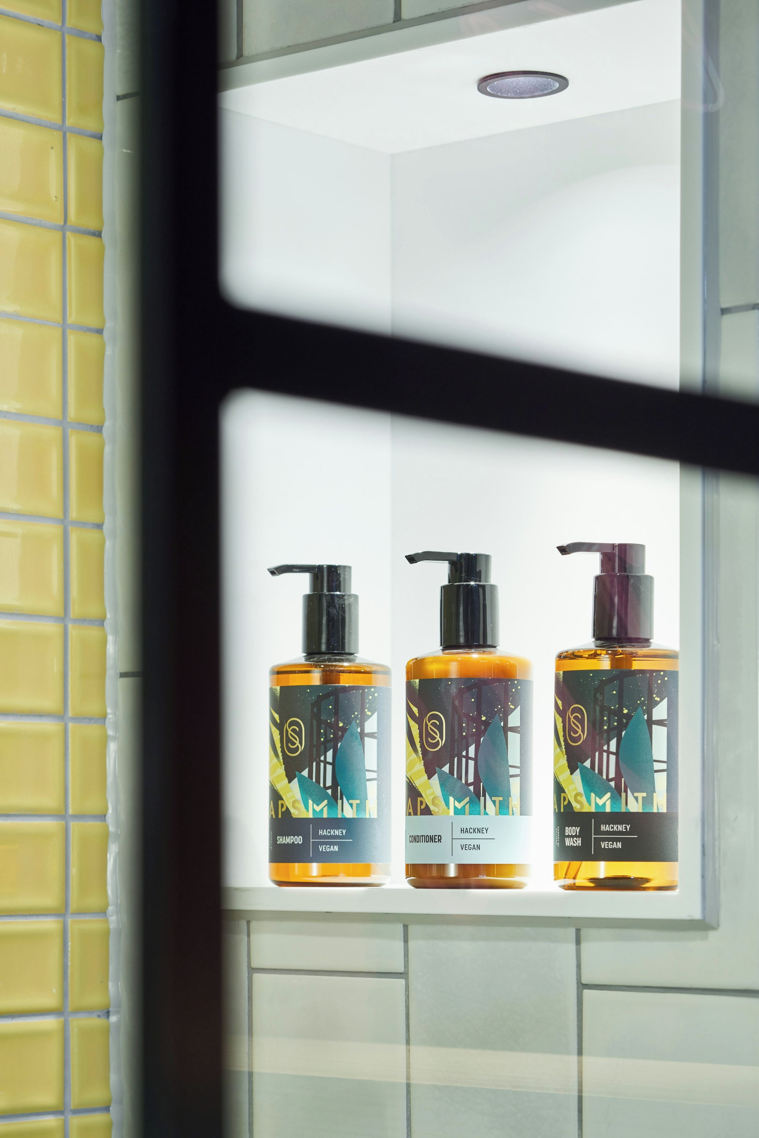 Three bottles of hair care products on a shelf.