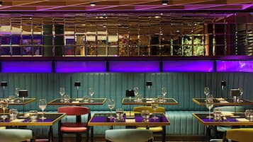 A restaurant interior with booths, tables, and a bar area.