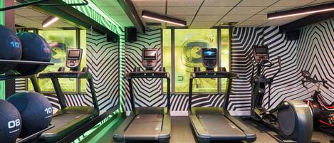 A gym with treadmills, a stationary bike, and weightlifting equipment.