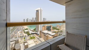 Un balcón con vistas a la ciudad, incluyendo edificios altos y un puerto deportivo.