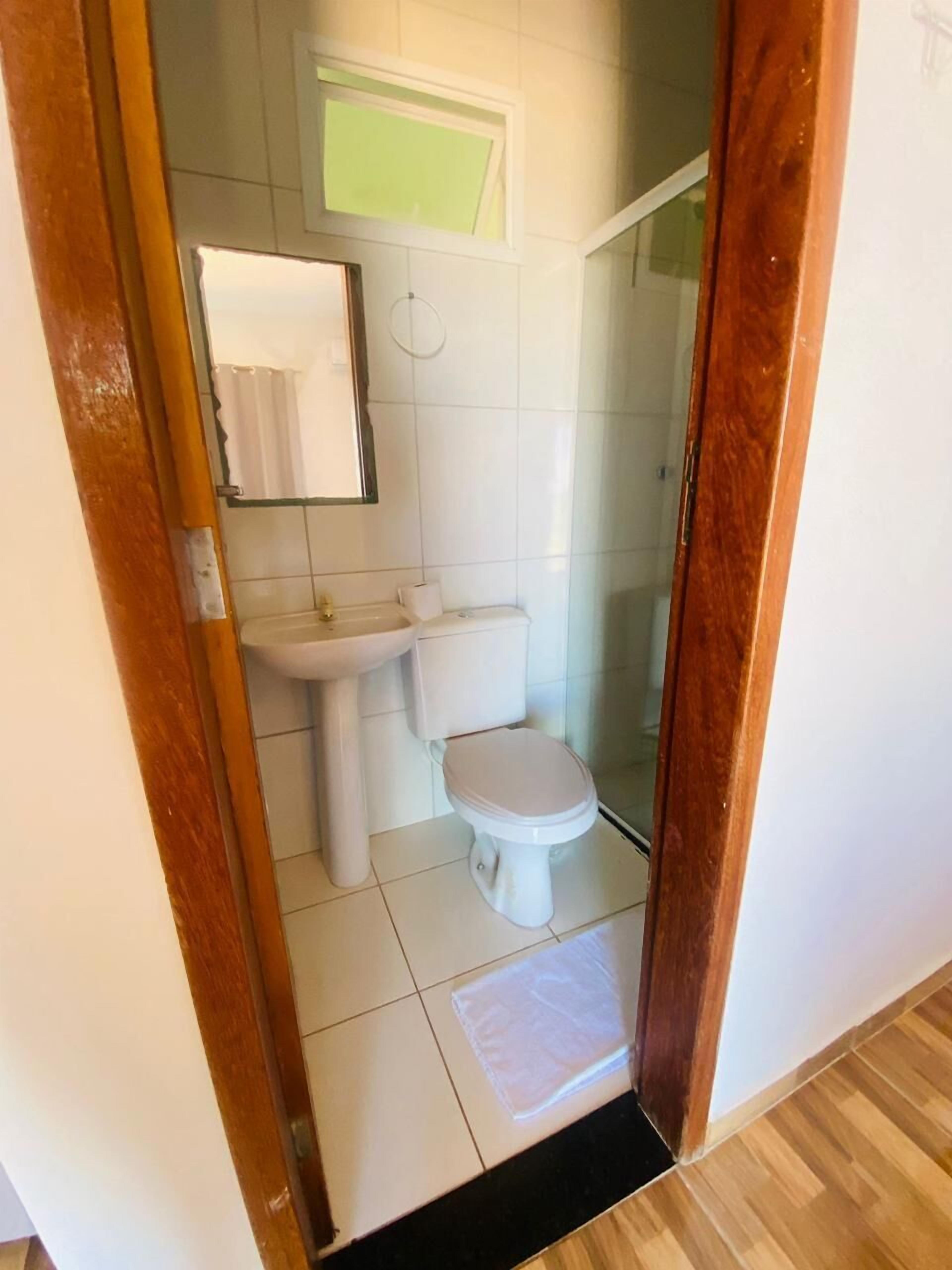 Casa de banho com sanita, lavatório e zona de duche.