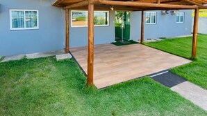 A modern building with a wooden pergola and a well-maintained lawn. - POUSADA SOL & MAR (Serra)