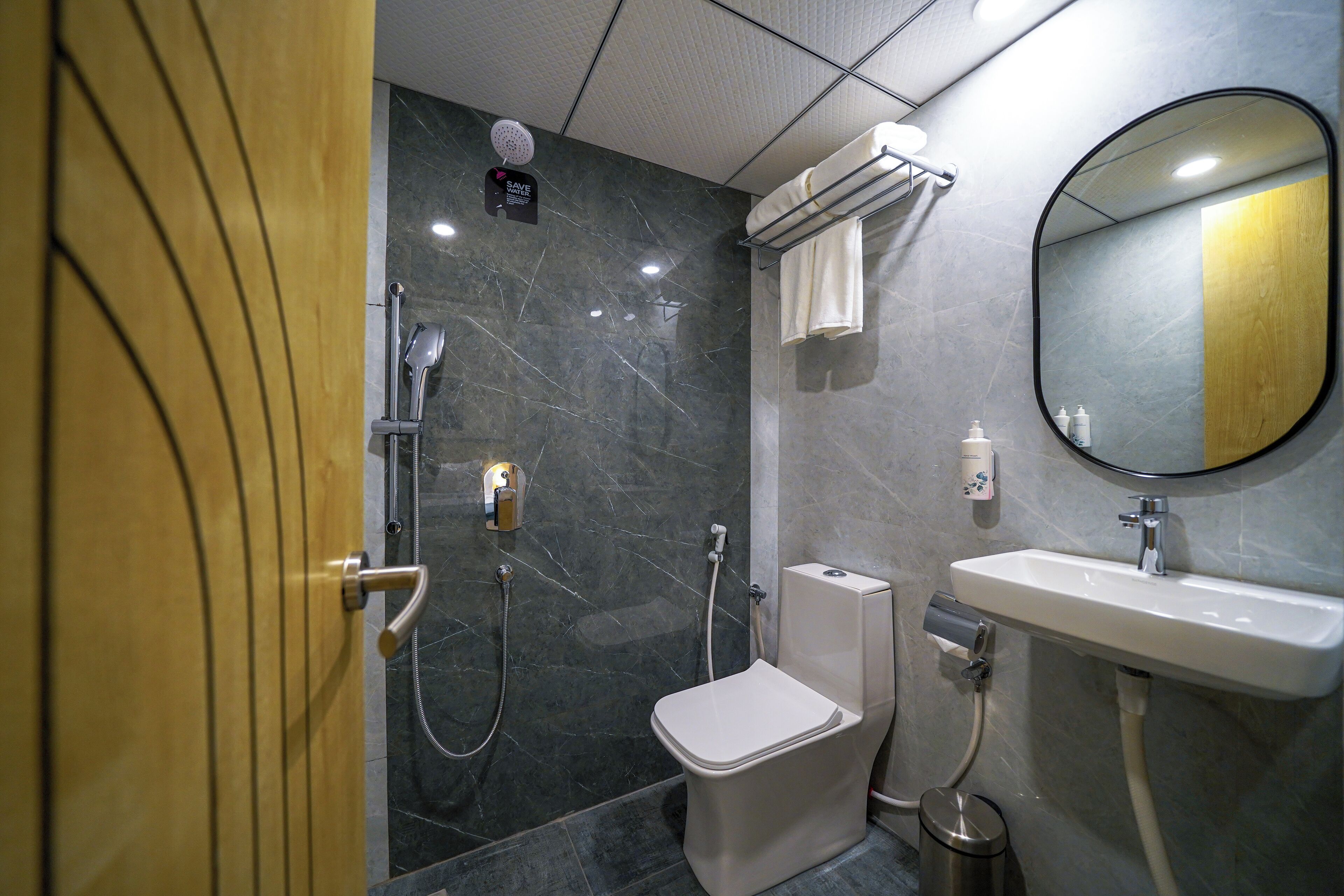 A modern bathroom with a toilet, shower, and sink.