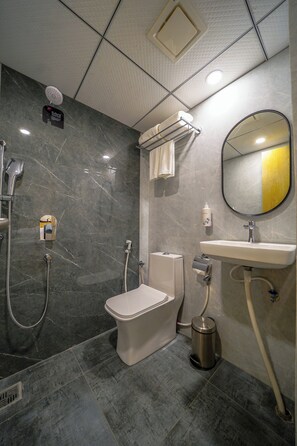 Une salle de bain moderne équipée de toilettes, d’un lavabo et d’une douche.