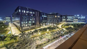 A modern building with multiple floors, large windows, and a well-lit exterior. - Olive Hotel Kundalahalli by Embassy Group (Bengaluru)