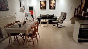 Un salon moderne comprenant une table à manger, deux canapés et un coin cuisine.