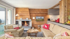 A cozy living room with a fireplace, wooden walls, and modern furnishings. - Cabane de la Delege -crans Montana- Amazing Views (Lens)