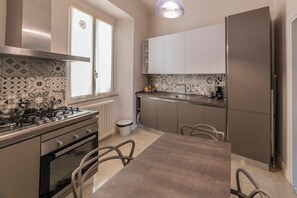 Una cocina moderna con estufa a gas, horno y refrigerador de acero inoxidable.