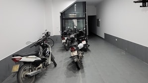 A parking garage with several motorcycles parked in rows. - Ruby Sun Home (Hanoi)